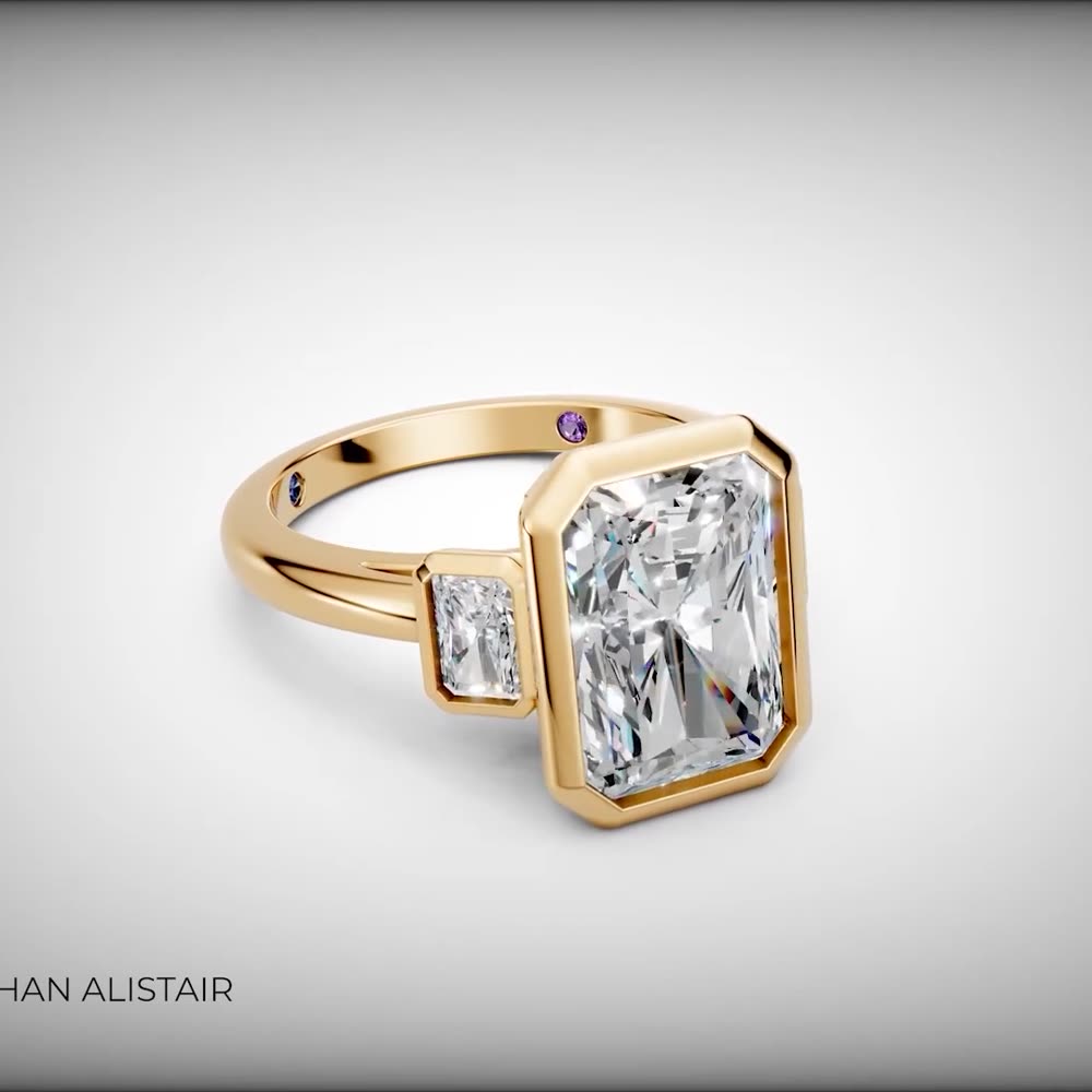 The Clifton — a bezel-set radiant cut diamond in yellow gold with accent side stone, custom commission by Jonathan Alistair