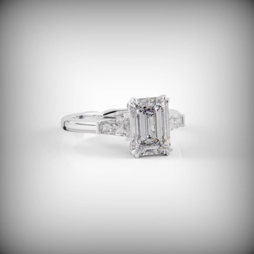 The Paarl — a platinum three-stone ring with an emerald cut center and tapered baguette side stones, custom commission by Jonathan Alistair